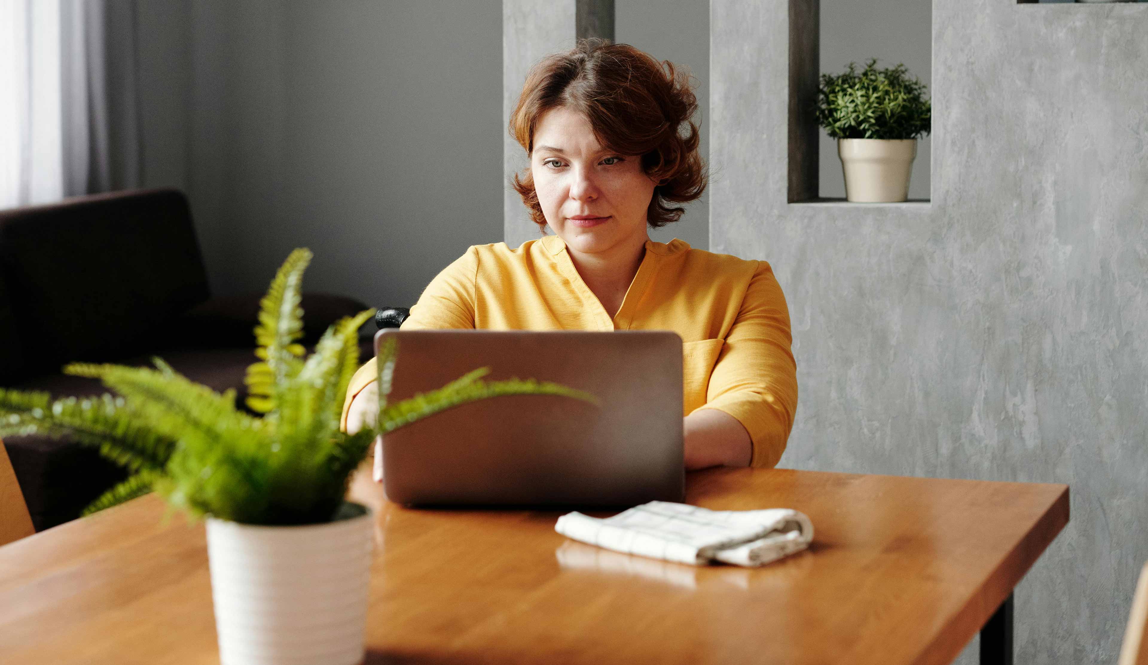 woman on her computer signing in on pdx tax virtual platform to submit her tax return documents